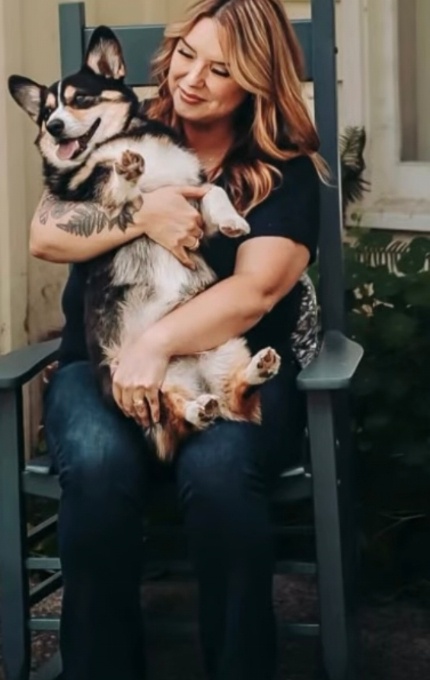 Rachel, the third grade CKLA teacher behind Blooming Minds & Hearts, holding her corgi on a porch rocking chair